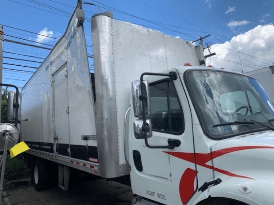 white box truck with a missing roof and damaged side in need of collision repair